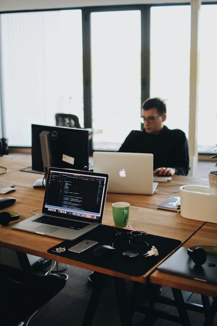Mastering the First Impression: Your intriguing post title goes here A web developer working on code in a modern office setting with multiple devices.