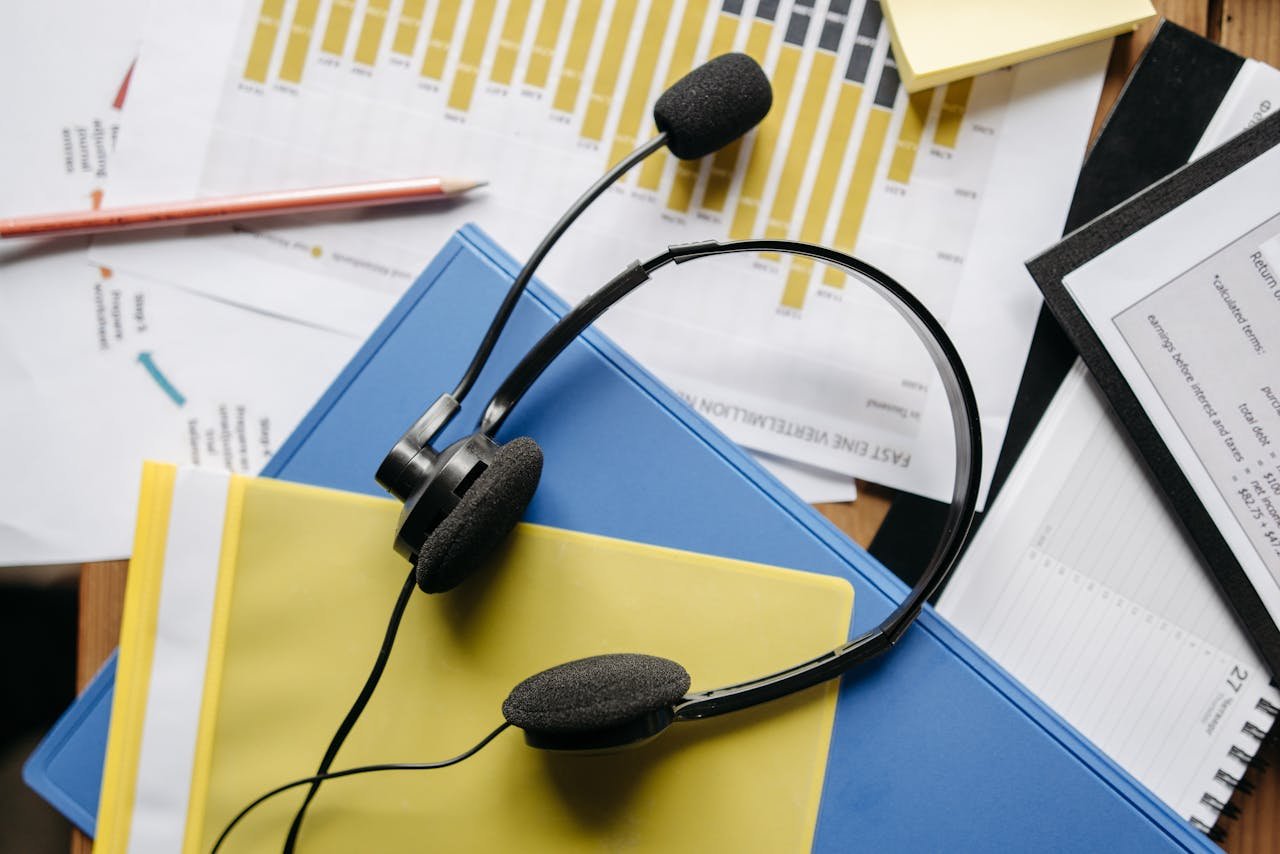 The Art of Drawing Readers In: Your attractive post title goes here Close-up of an office desk with headset, charts, and documents showcasing customer service support.